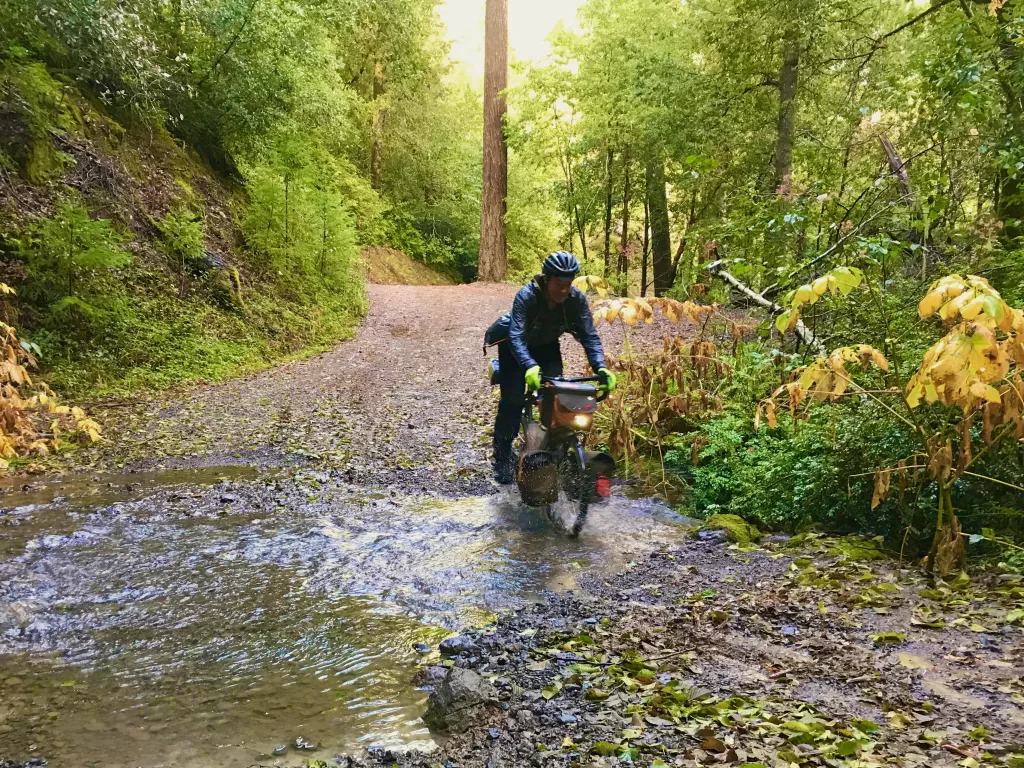 gravel cyclist crossing a stream